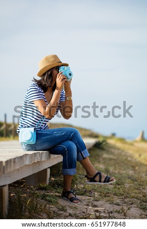 young woman taking a photo in the countryside