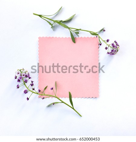 Flat layout with little flowers and blank pink card top view / background for invitations and congratulations