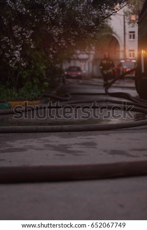 firefighters extinguish a fire in an old brick house