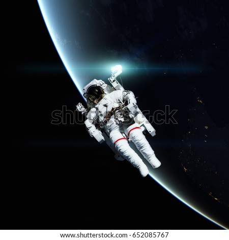 Astronaut in outer space. Planet Earth on the background. Elements of this image furnished by NASA.