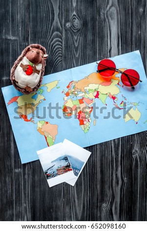 accessories for treveling with children, map and photos on dark woode background top view
