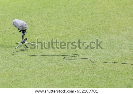 Close-up the professional sport microphone and set situated on the green grass for sport broadcasting.