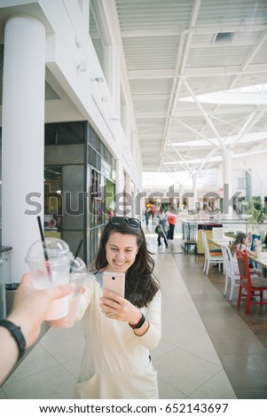Woman Drinking Smoothie while walking the mall man firt-person view