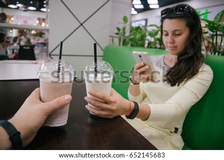 first-person view on woman taking picture of smoothie in cafe