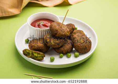 Hara Bhara Kabab or Green Peas Pakora, Popular indian starter food served in a plate with Tomato and Mint Chutney over moody background. Selective focus Royalty-Free Stock Photo #652192888