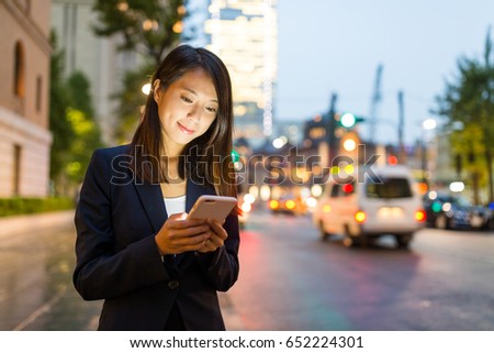 Business woman use cellphone in Tokyo city at night