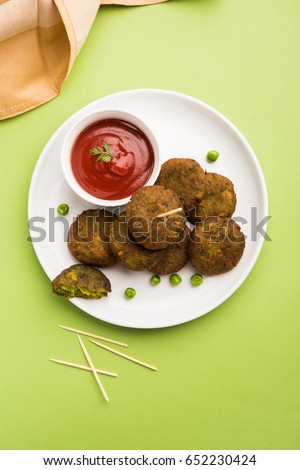 Hara Bhara Kabab or Green Peas Pakora, Popular indian starter food served in a plate with Tomato and Mint Chutney over moody background. Selective focus Royalty-Free Stock Photo #652230424