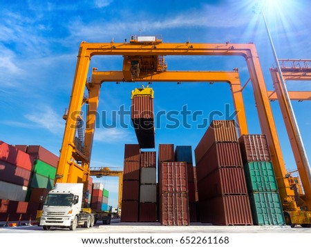 The RTG(Rubber Tried Gantry Cranes) pick up full loaded containers on truck at industrial port and container yard for delivery to customers Royalty-Free Stock Photo #652261168