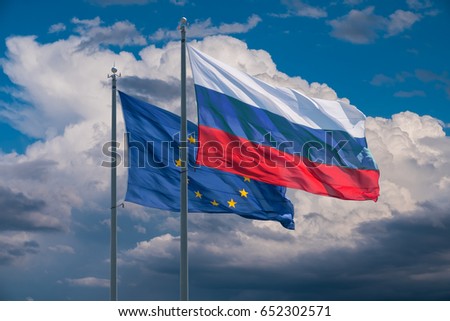 European Union and Russia flags on background of clouds