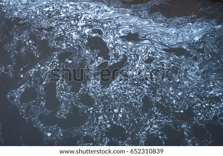 Closeup image of white foam stains on the  river sutface