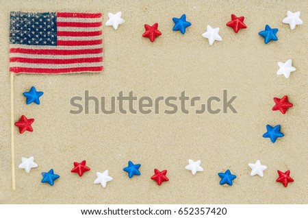 Patriotic USA background with white, blue and red stars and American flag on the sandy beach