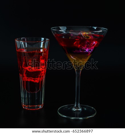 Colorful drink in a cocktail glass, with ice cubes, summer drink, party night