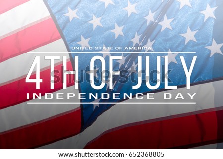 Text 4th of July - Independence Day on flowing American flag background. Concept of American Independence celebration. Happy Independence Day or Fourth of July banner.