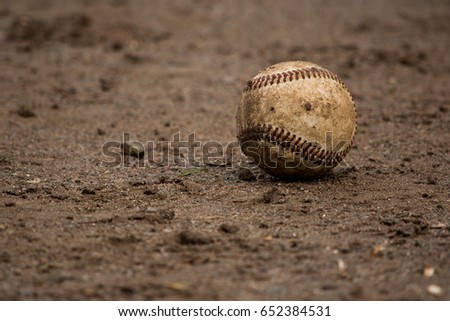 Baseball: A dirty baseball lies on the infield on game day. Royalty-Free Stock Photo #652384531