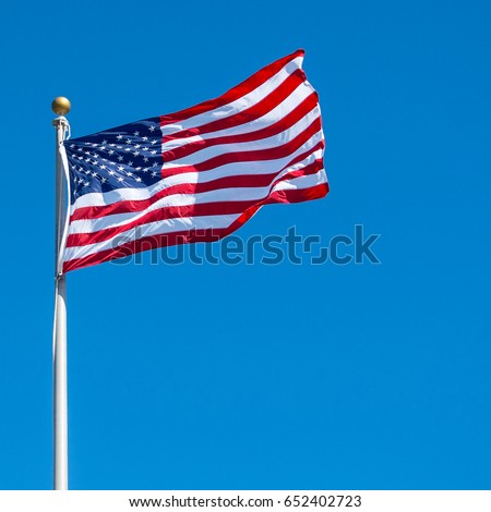 An American flag waving in the clear blue sky