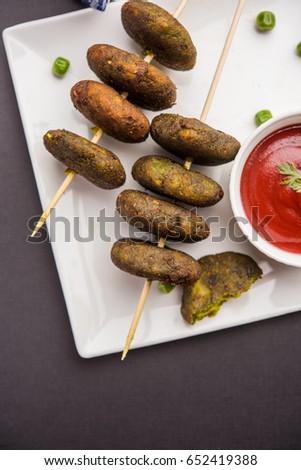 Hara Bhara Kabab or Green Peas Pakora, Popular indian starter food served in a plate with Tomato and Mint Chutney over moody background. Selective focus