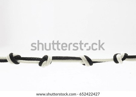 White rope and black ropes tied knot on white background.