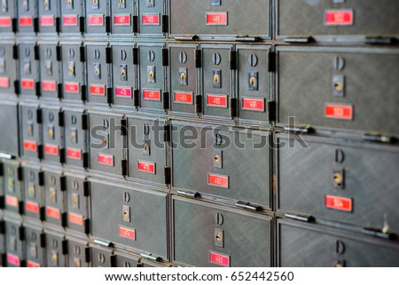 Rows of many locked post office boxes with red number labels