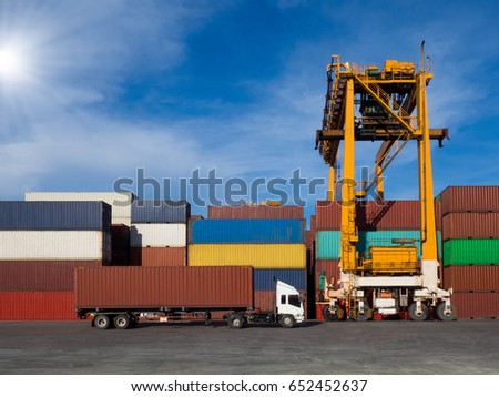 The RTG(Rubber Tried Gantry Cranes) pick up full loaded containers on truck at industrial port and container yard for delivery to customers Royalty-Free Stock Photo #652452637