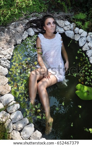 Nature pond model fashion concept girl in a white dress in a pond
