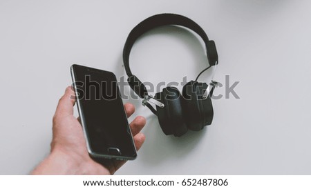 External earphones and telephone on white background with close-up.