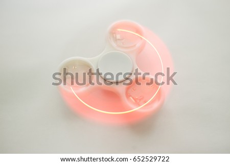 Fidget spinners with led light, stress relieving toy. Motion blur due to slow shutter speed applied