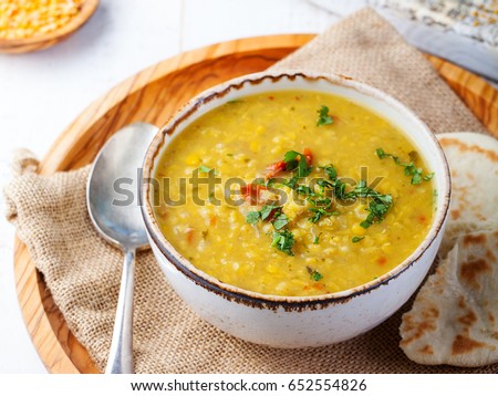 Lentil soup with pita bread in a ceramic white bowl on a wooden background. Close up. Royalty-Free Stock Photo #652554826