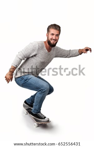 Attractive young man with a beard has fun on a skate board
