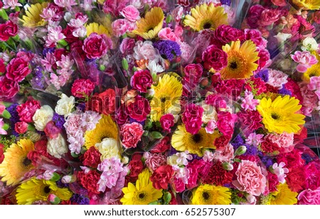 Fresh flowers in outdoor flower market. Red, pink, yellow, white carnations, yellow gerbera. Floral background. Royalty-Free Stock Photo #652575307
