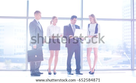 Portrait of young businesswoman in office with colleagues in the background