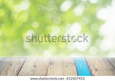 Blur green nature bokeh leaf with sun light on copy space empty old wood table abstract background. Product presentation in fresh nature. Ecology environment and nature concept.