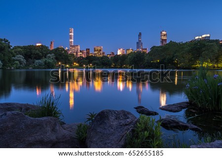 Central Park Lake with view of Manhattan skyline at night in New York City, NY