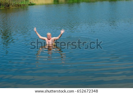 Landscape , lake in the woods. drunk man swims in the lake.