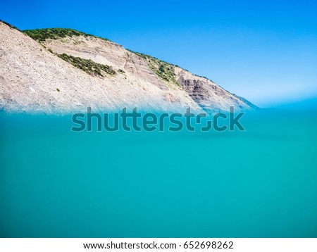 Underwater in sea and mountains and blue sky.