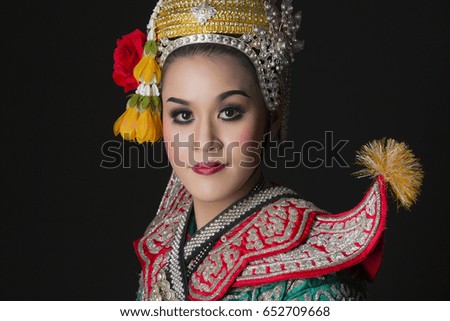 woman performing typical thai dance with black background, identity culture of thailand