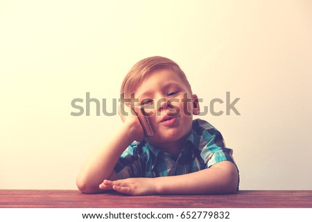 Pensive little boy talking on the phone