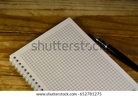 Notebook with the fountain pen on a wooden table
