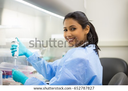 Closeup portrait, scientist pipetting from 50 mL conical tube with blue liquid solution, performing laboratory experiments, isolated lab . Forensics, genetics, microbiology, biochemistry Royalty-Free Stock Photo #652787827