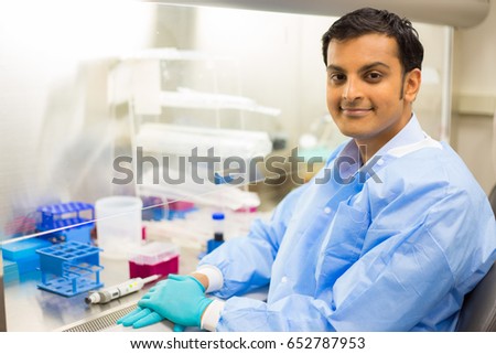 Closeup cropped portrait, scientist  sitting in front of laboratory experiments and fume hood, isolated lab background. Forensics, genetics, microbiology, biochemistry Royalty-Free Stock Photo #652787953