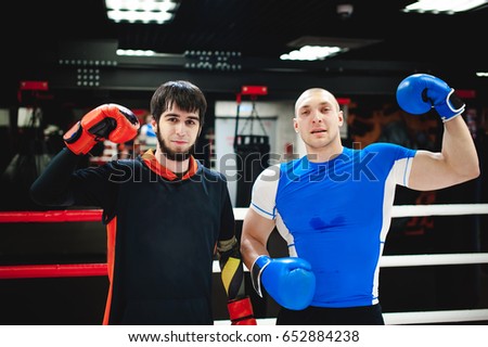 Professional Muay Thai fighter. Male boxer in training sportswear, an exercise in sports hall, fight with a shadow in ring, Strike testing Sparring partner