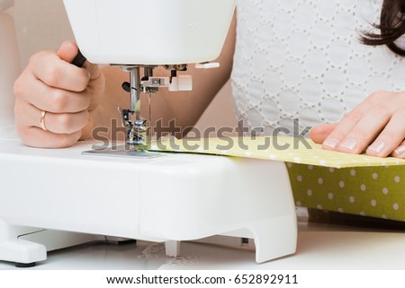 Female hands working for the white sewing machine. Scrapbooking for wedding or other festive decorations . Tools for scrapbooking.