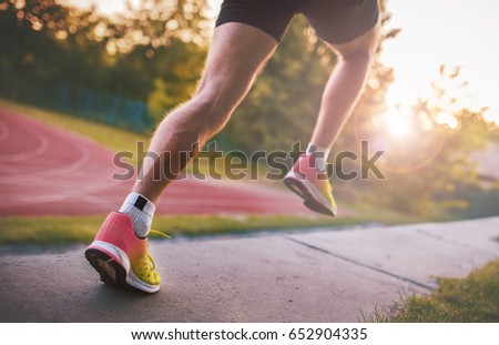 Athlete running in the park. Closeup photo of legs and running shoes. Sport, fitness, workout concept