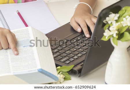 girl writing and reading a book dictionary english for study and computer notebook