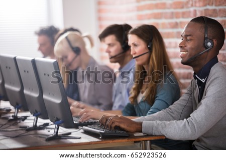 Young Call Center Team Talking With Customers Royalty-Free Stock Photo #652923526