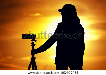 Female photographer with camera during sunset