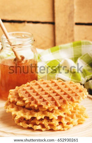 Few waffles and glass with flower's honey, soft focus background