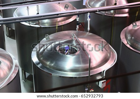 Metal tanks for storing and ripening beer. Picture of the top of the tank. Modern brewing production.