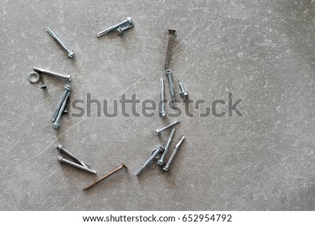 Construction tools. The screws, nuts and bolts on concrete background. Repair, home improvement concept. Top view, flat lay.