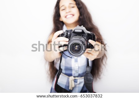 Cute brunette little girl holding an photo camera, isolated on white background