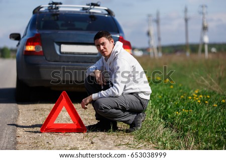 Young man near broken car